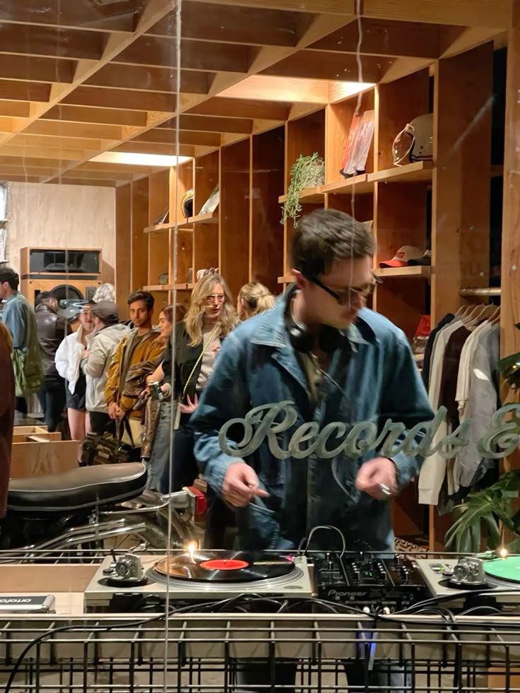 DJ legt Vinyl auf, umgeben von Gästen